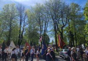 uczniowie wchodzą na plac ze sztandarem