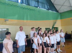 uczniowie w czasie zakończenia roku szkolnego wraz z dyrektor K. Olejniczak i raperem K. Łyszkowskim