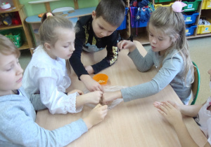 Dzieci pracują z zaangażowaniem przy stoliku