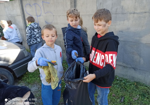 Uczniowie trzymają w rękach śmieci.