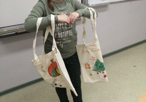 Uczennica prezentuje swoje ekologiczne torby