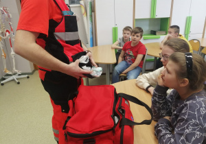 uczniowie oglądaja torbę ratownika medycznego