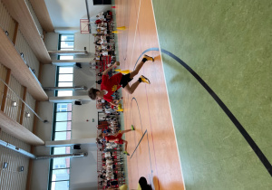 Uczeń biegnie z piłeczką tenisową.