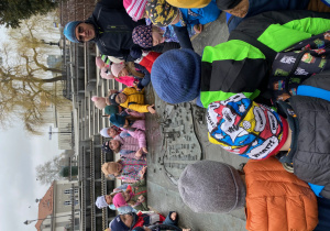 Uczniowie stoją wokół makiety miasta i słuchają przewodnika.