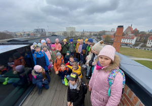 Uczniowie stoją na tarasie widokowym- zbiorowe zdjęcie, a w tle panorama miasta.