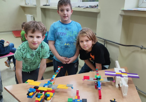 Trzech chłopców prezentuje swoje budowle