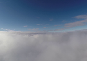 Zdjęcie wykonane z gondoli balonu stratosferycznego. Kamera znajduje się na poziomie górnej warstwy chmur, powyżej widać błękitne niebo, poniżej gęstą warstwę białych chmur.